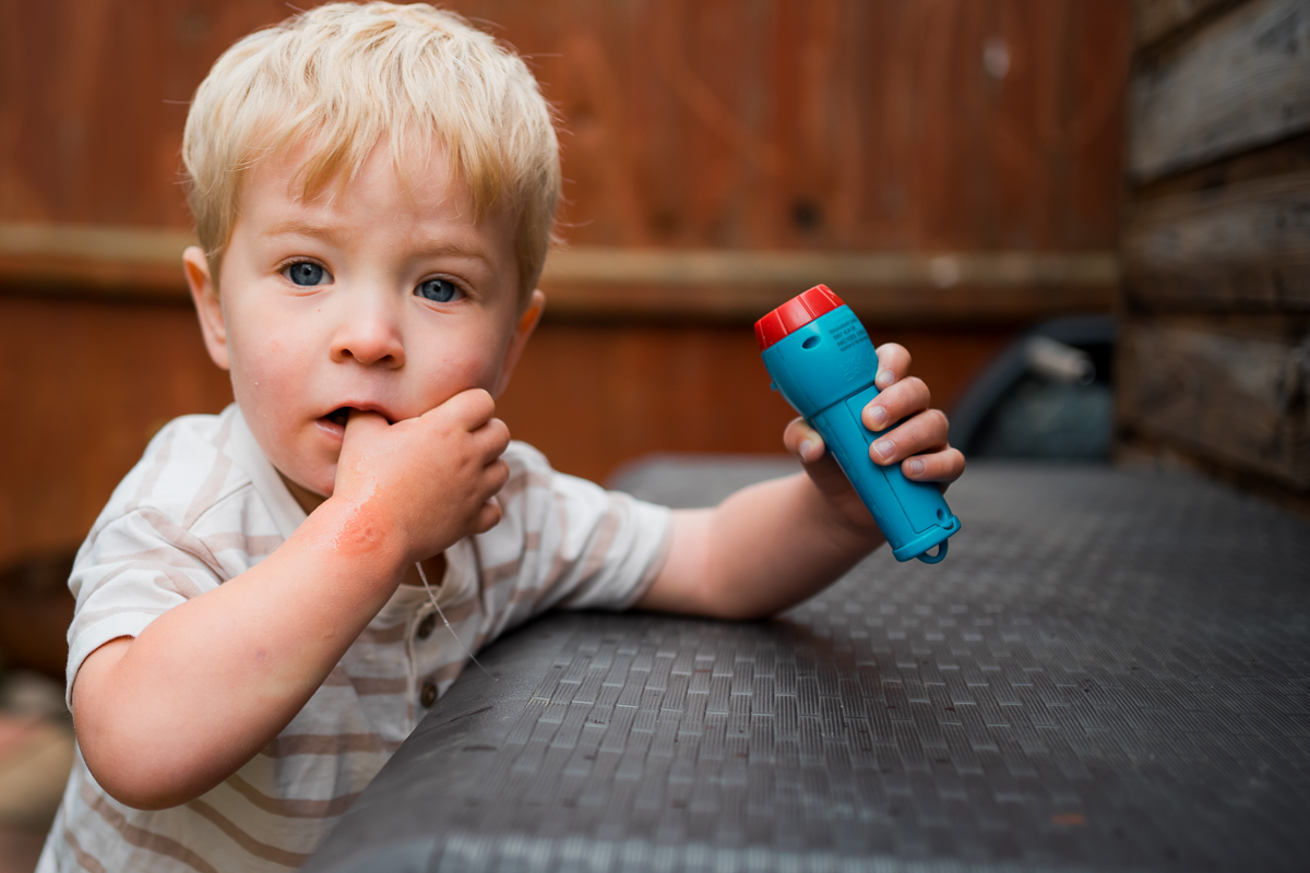 Candid environmental portrait of a young boy holding a torch in his hand.